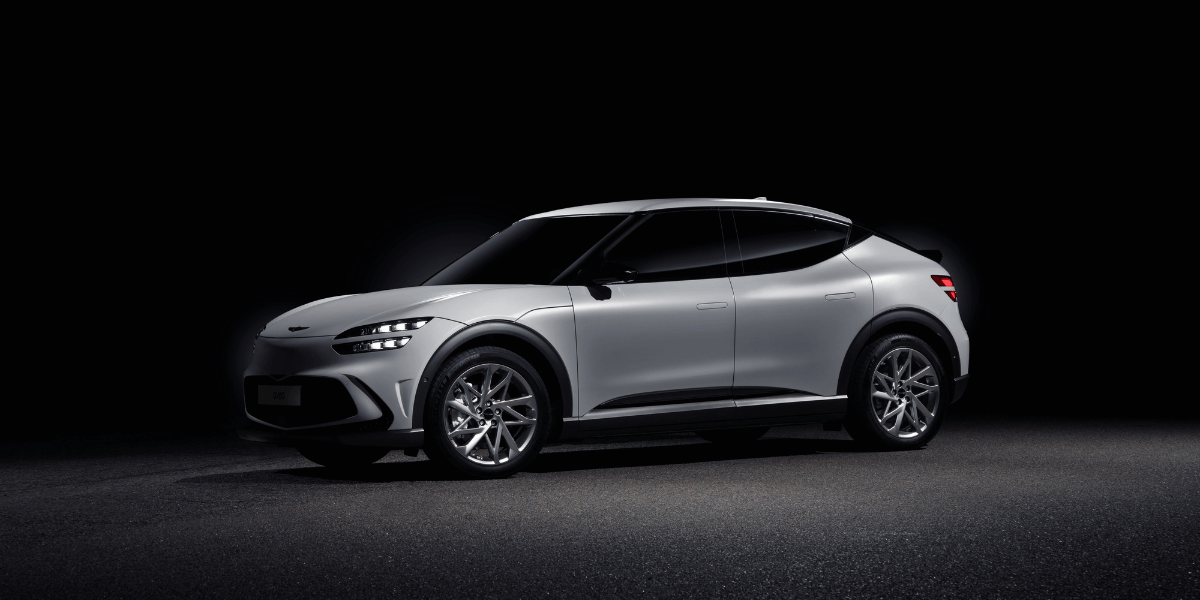 Silver Genesis SUV photographed in a dark studio setting, highlighting the vehicle’s sleek profile and modern design.