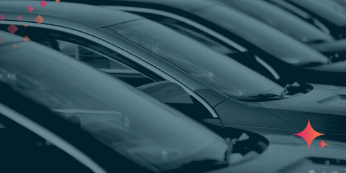 Row of parked vehicles highlighting windshields and hoods in a dealership lot.
